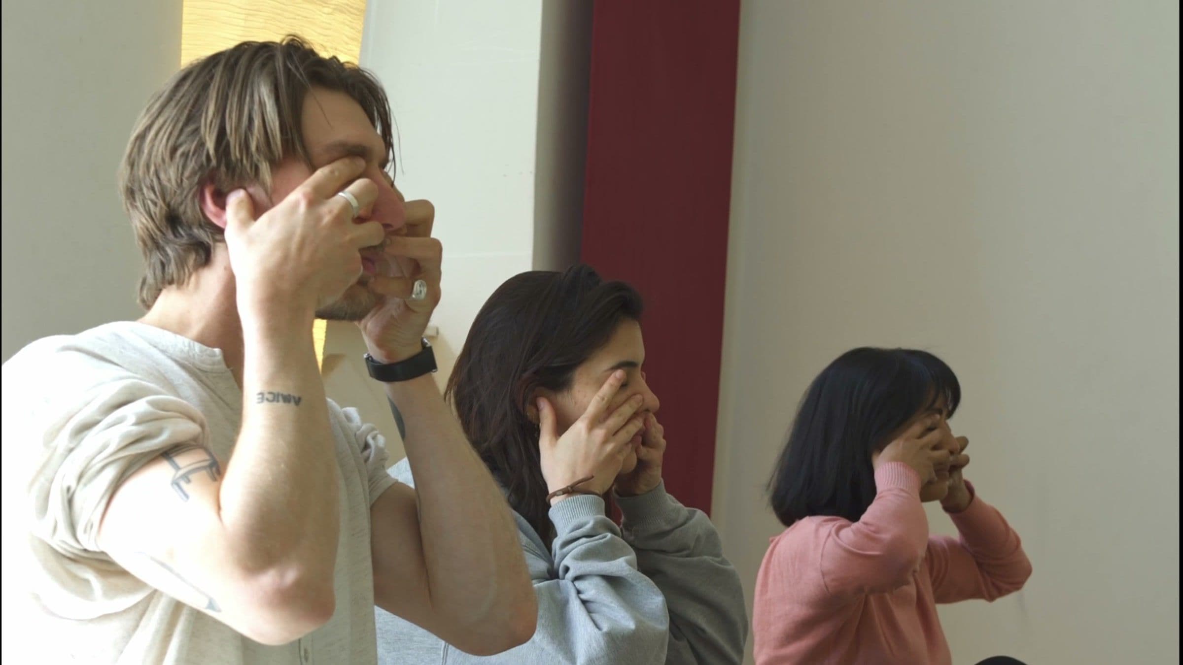 Drei Teilnehmer üben die Wechselatmung während einer Pranayama-Ausbildung bei Yogicescape Berlin