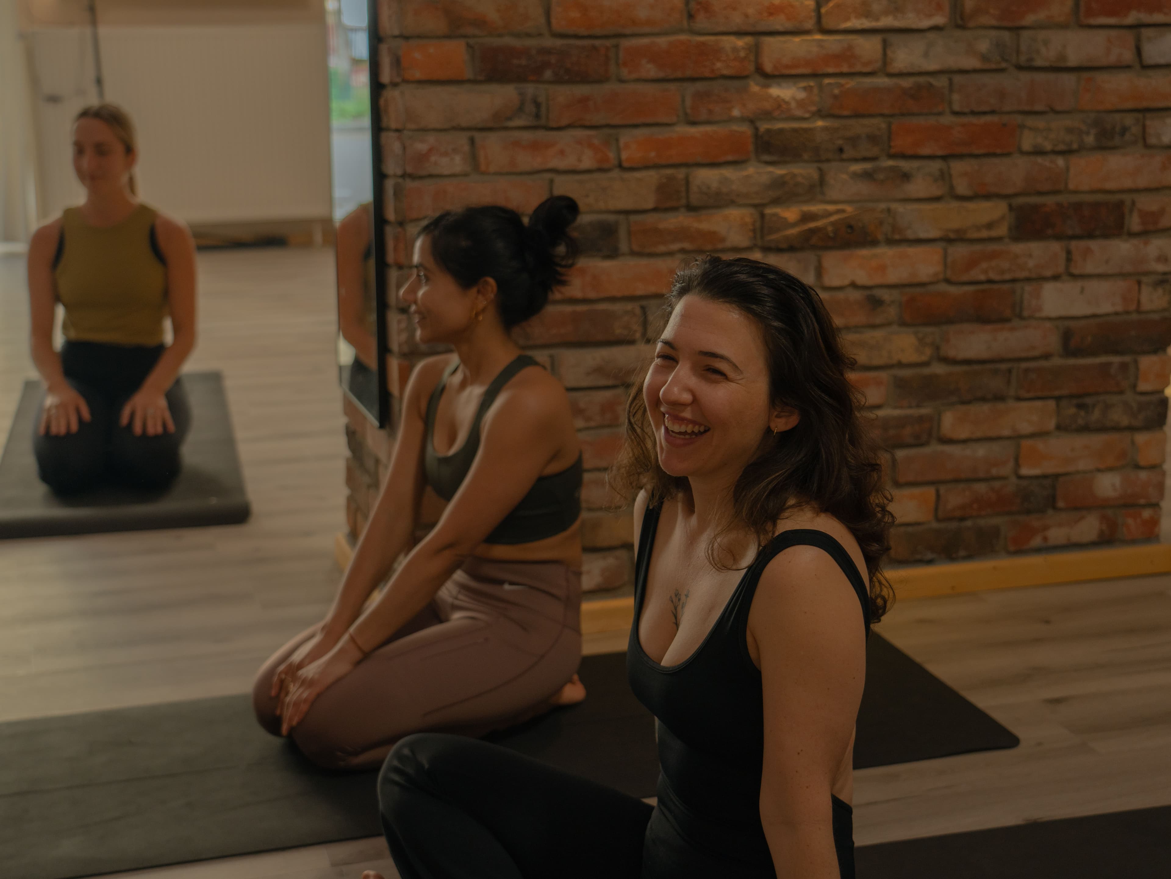 Zwei Teilnehmerinnen lachen nach dem Kurs im Yogicescape Friedrichshain Yoga Studio in Berlin