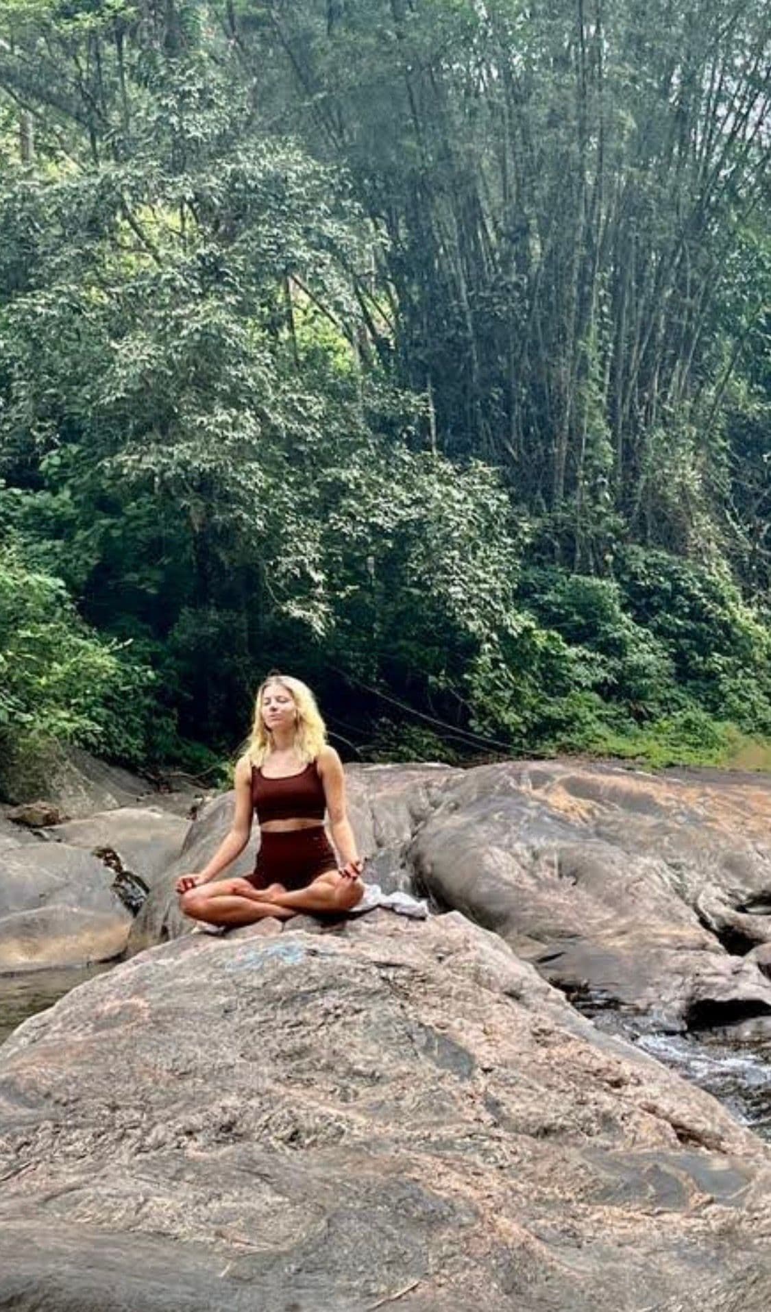 Lilly Passora meditiert an einem Wasserfall im Dschungel