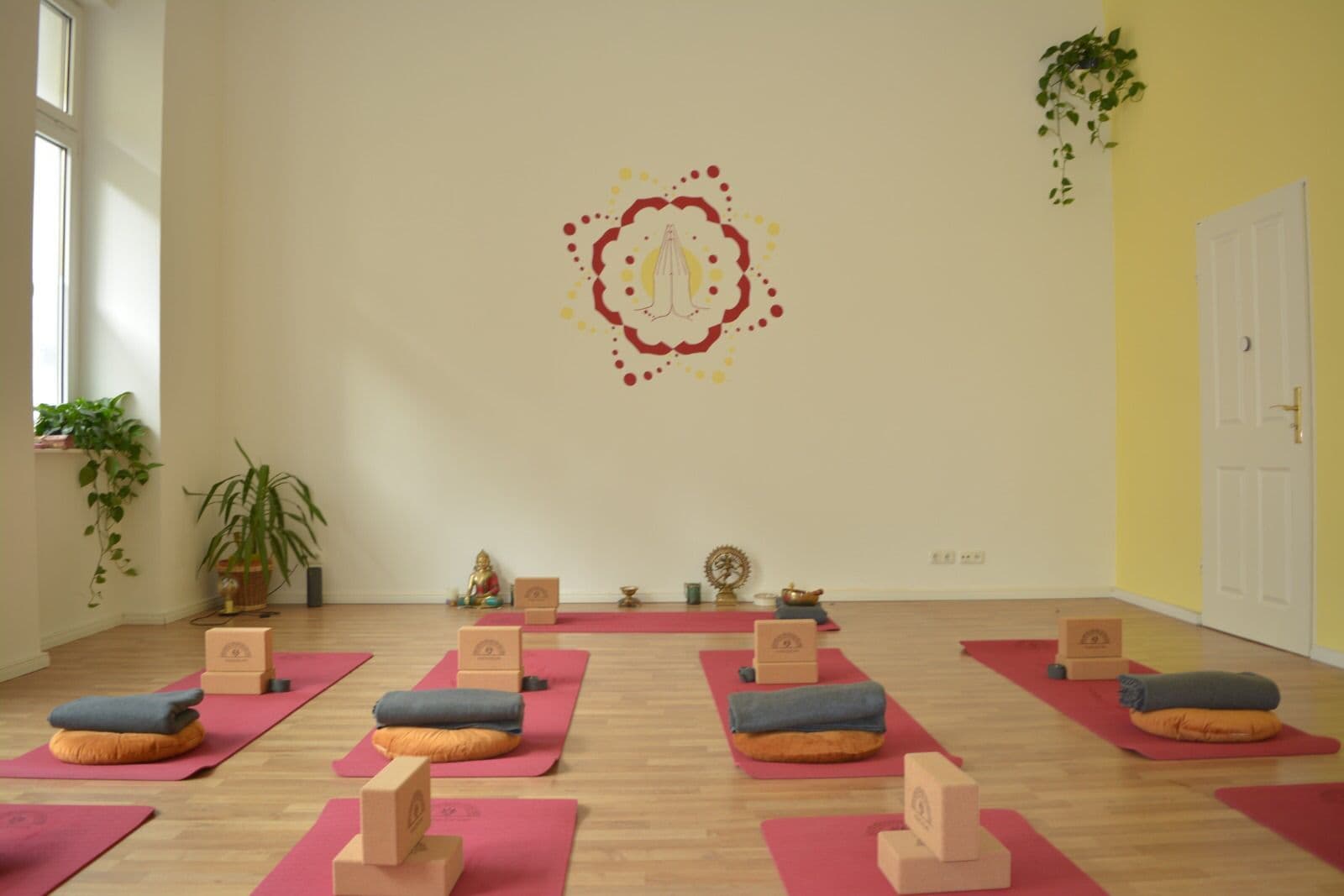 Rote Matten, Decken und Korkblöcke liegen bereit zur Stunde im Yogicescape Studio Berlin
